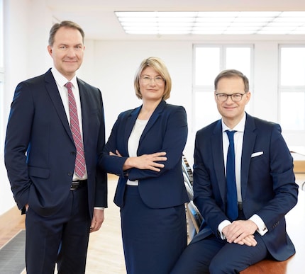 Three members of the Jenoptik Executive Board 2023 in an office with light windows