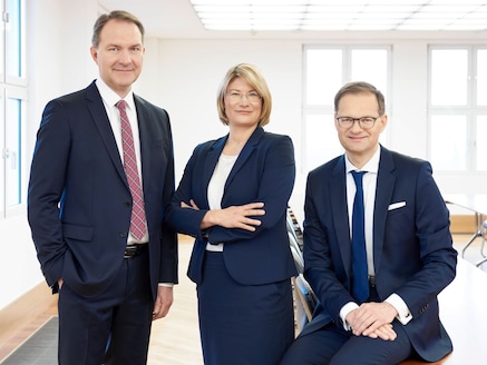 Drei Mitglieder des Jenoptik-Vorstands in hell erleuchtetem Büro