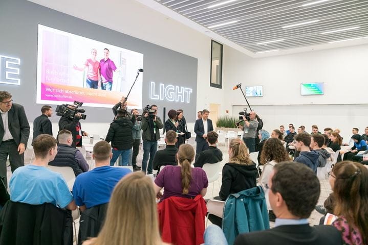 Journalists film the Minister's arrival in the staff restaurant